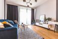 Wohnzimmer mit Sofa, Essbereich und Zugang zur Terrasse